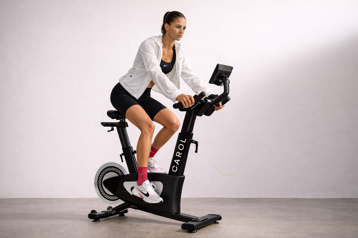 A woman riding a CAROL exercise bike, mid-workout